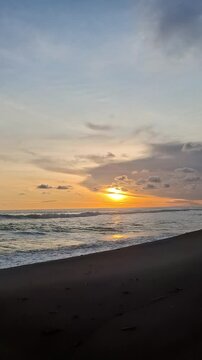 sunset over the sea on the edge of the black sand beach