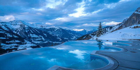 Luxury winter resort with infinity pool and snow mountain views in swiss alps for travel and tourism