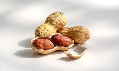 Close up of peanuts in shell and shelled on white background healthy snack food photography studio shot 100 characters