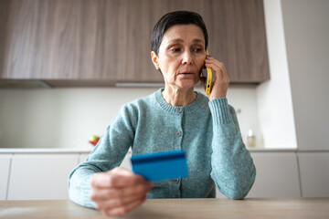 Scared nervous woman transferring money to scammers over phone. Fraud deception, bank card...
