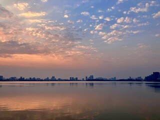 Tranquil Waterfront Dreamscape: Soft Clouded Sunset Reflection on West Lake in Hanoi, Vietnam