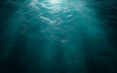 Underwater scene with sunbeams penetrating deep ocean water.