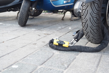 Fototapeta premium Motorcycle secured with a lock on a city street during daytime