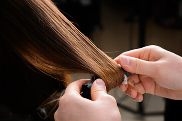 A hairdresser perming a woman's hair
