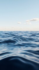 Fototapeta premium A tranquil seascape featuring gentle waves under a clear sky, creating a serene atmosphere with soft clouds in the distance.