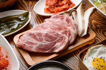 Grilled pork and mushrooms on a wooden plate
