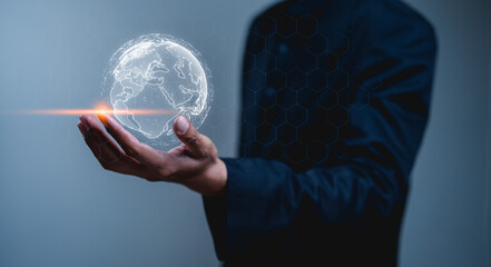 Businessman in a suit holds a glowing globe, symbolizing technology and global connectivity in a...