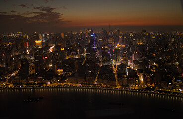 Evening descends upon Shanghai, wrapping bustling city in twilight. Lights from buildings and the...