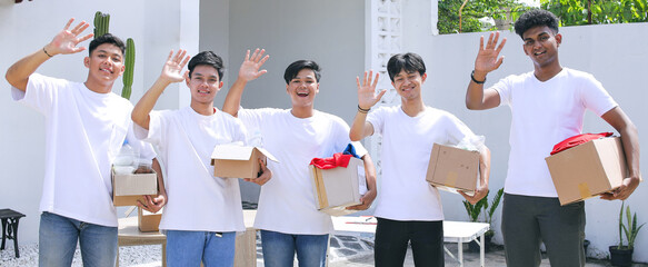 Portrait of Five People Holding Donation Cardboard Boxes and Waving Hands During Charity