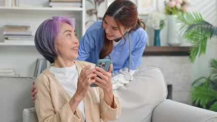Young asian caregiver or woman nurse hand on senior female shoulder give support empathy to care,consulting and encourage,take a history and recommend the right treatment to live happily in retirement