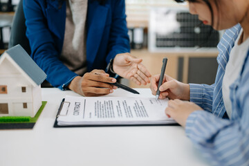 Real estate broker agent presenting and consult to customer to decision making sign insurance form agreement, home model