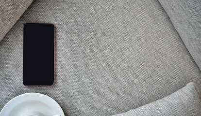Flat Lay, Top view smartphone mockup and  a cup of black coffee on fabric textile with copy space, digital NOMAD, freelancer workplace or online shopping concept