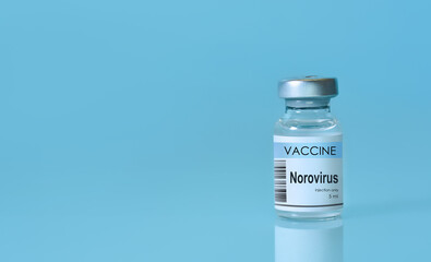 Norovirus vaccine bottle standing upright on a clean blue background, representing the concept of immunization, advanced medical science, disease prevention,global healthcare awareness. Copy space.