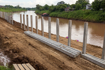 Many concrete pillars are on the ground to construct a dam.