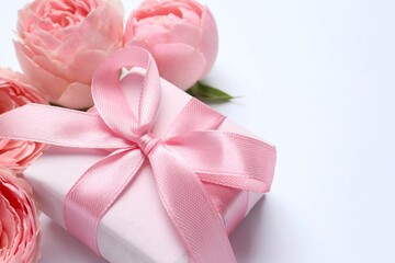 Beautiful pink peony roses with gift box on white background