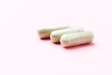 Barley grass capsules. Antioxidants. Concept for a healthy dietary supplementation. Bright background. Soft focus. Close up. Copy space.