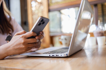 digital nomad is working in cafe while using laptop and smartphone to stay connected and productive in cozy environment. atmosphere is relaxed and inviting