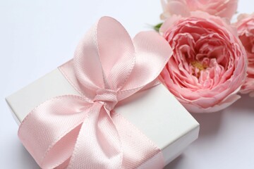 Beautiful pink peony roses with gift box on white background, space for text