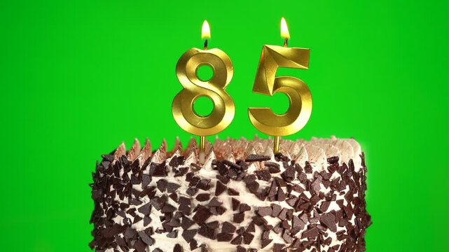 Burning candles number 85 on birthday cake against chroma key background. Eighty-fifth birthday. Concept of Birthday celebration