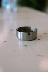 Simple Stainless Steel Ashtray on Spotted Countertop, Close-Up View