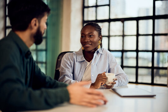 Friendly Colleagues Talking Over Coffee in a Modern Office Setting