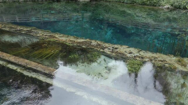 Drone footage of Stifone and the Morica spring in Umbria, Italy: turquoise waters, lush nature, stone ruins, and peaceful river views in a hidden, historic valley.