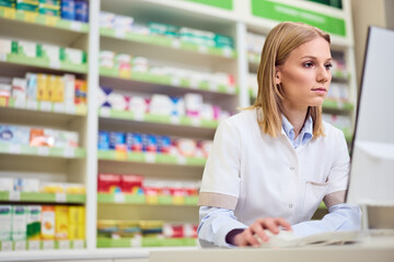 Professional Pharmacist Working on Computer in a Modern Pharmacy Setting