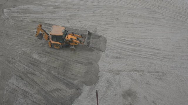 Prayagraj,India-6 January 2025 Before the Kumbh Mela the sandy ground on the banks of the Ganga is being leveled by JCB Backhoe loader for the convenience of the public at Prayagraj UP India