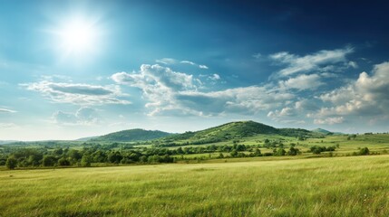 Obraz premium A breathtaking landscape featuring rolling green hills under a bright blue sky with fluffy clouds and a shining sun.