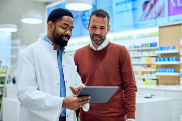Pharmacist Assisting Customer with Digital Tablet in Modern Pharmacy Environment