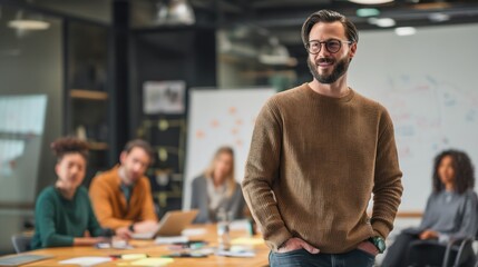 Obraz premium A confident man stands in a modern office, surrounded by team members engaged in discussion and collaboration.