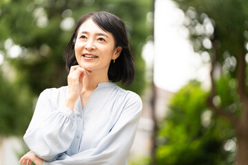 外で立っているミドル女性　ライフスタイルイメージ