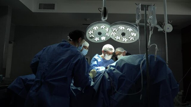 Surgical team performing complex operation under bright lights