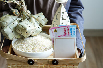 Close Up Of Hands Holding Zakat Gift Package With Rice And Rupiah Money