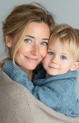 Happy mother and child in blue sweaters smiling