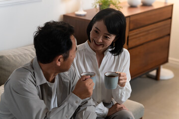 マグカップで飲み物を飲むミドル夫婦　ライフスタイルイメージ