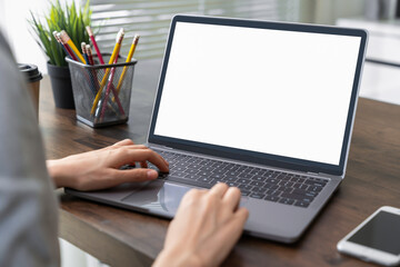 Hand using a computer laptop with a blank screen on table, for putting advertising to promote