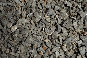 Cracked asphalt background.Black textured view.Road construction materials.Urban style.Black stones. 
