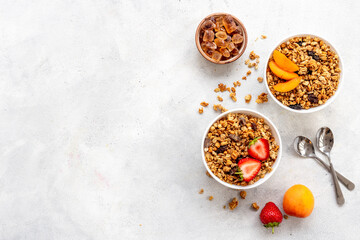 Bowl with oatmeal granola and ingredients - apricots and strawberry. Top view