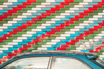 Fototapeta premium Car roof next to the brick wall with Azerbaijan flag pattern painted bricks