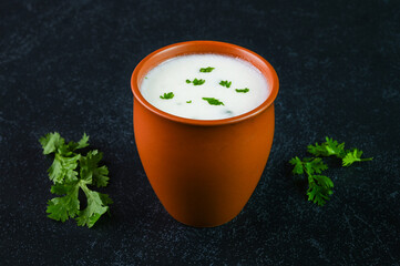Serving buttermilk drink in a mud cup.