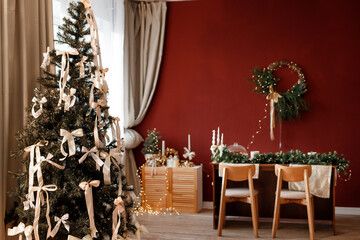 Beautifully decorated New Year's room. A festive table with candles, a decorated Christmas tree