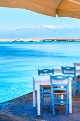 Sea, cafe tables and snow mountains in Peloponnese, Greece