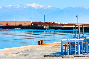 Sea, cafe tables and snow mountains in Peloponnese, Greece