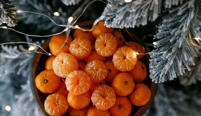 Plate with tangerines under a beautiful New Year tree. View from above