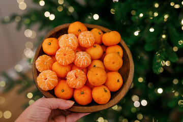 Plate with tangerines under a beautiful New Year tree. View from above