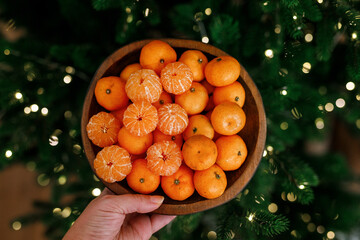 Plate with tangerines under a beautiful New Year tree. View from above