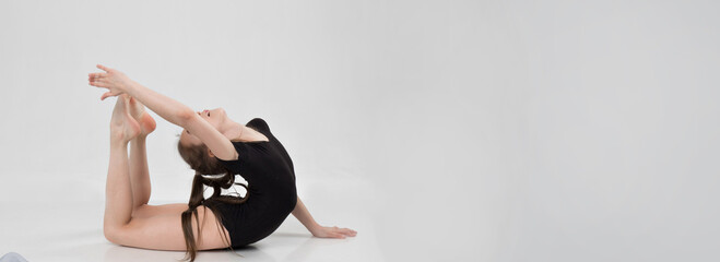 A girl in a swimsuit and a dress shows beautiful athletic elements on a white background. Ballet, rhythmic gymnastics, fabric, aesthetics, grace