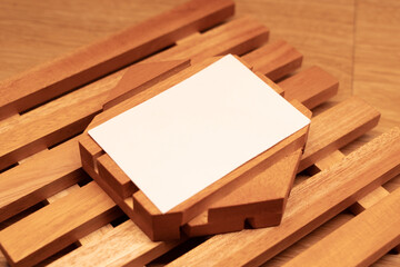 White blank business card mockup with wooden decoration on wooden background