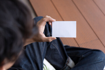 Fototapeta premium A man holding white blank business card mockup